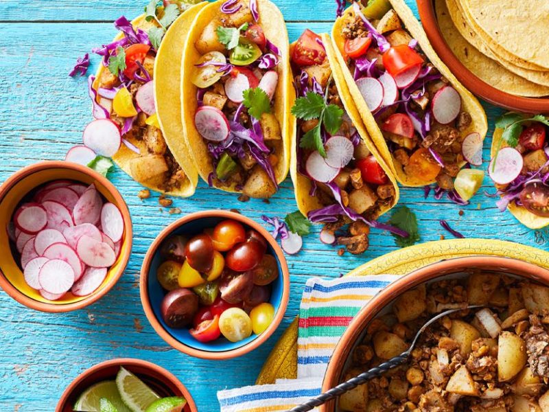 Plant-based tacos with a mushroom chorizo filling served on a blue table