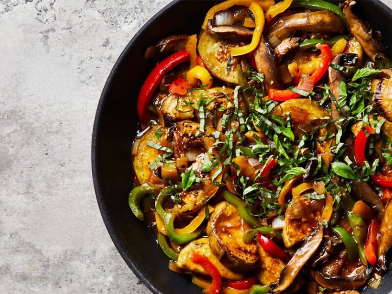 Thai Basil Eggplant in a dark blue bowl on a gray countertop