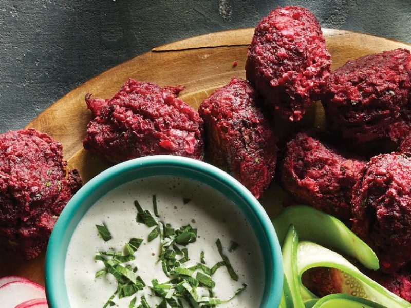 Roasted Beet Falafel with Chile-Lime Tahini Sauce on a round wooden platter