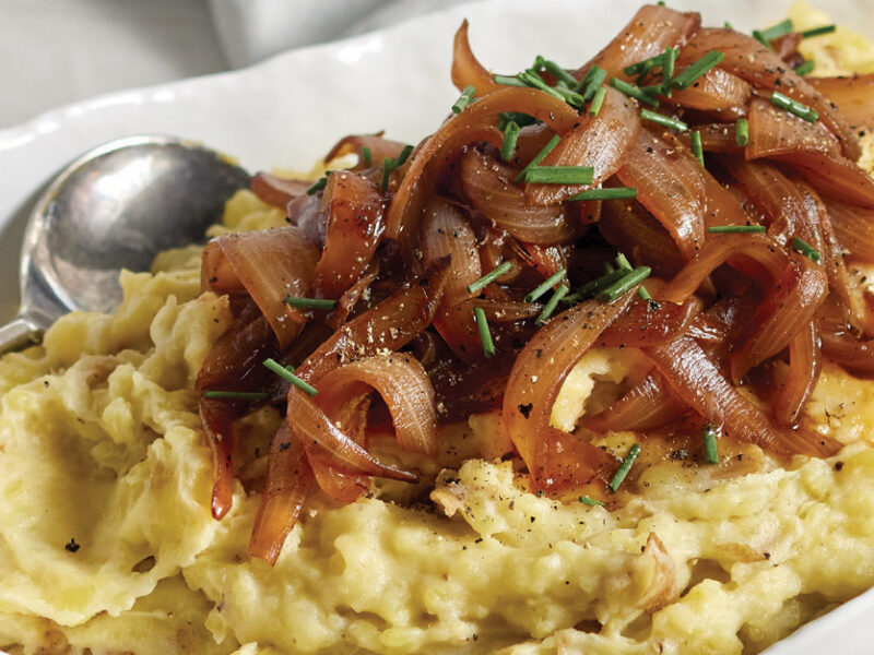 Caramelized Onion Mashed Potatoes in a white ceramic serving dish