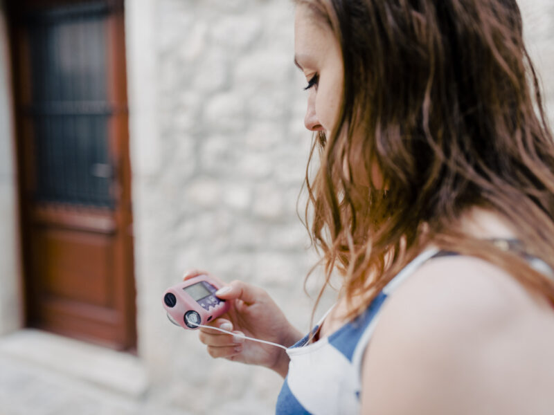 Young woman with Type 1 diabetes reading her insulin pump