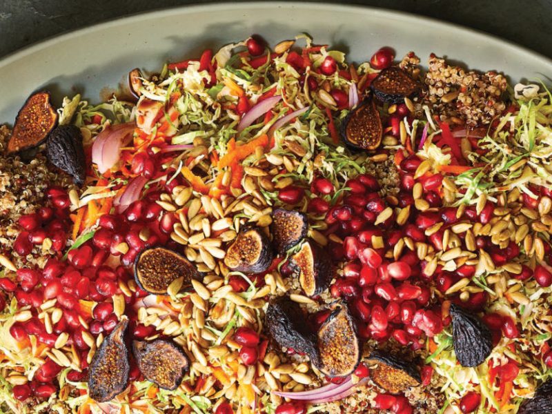 Crunchy Brussels Sprout Slaw with Figs, Pomegranate and Quinoa in a large pale green ceramic platter