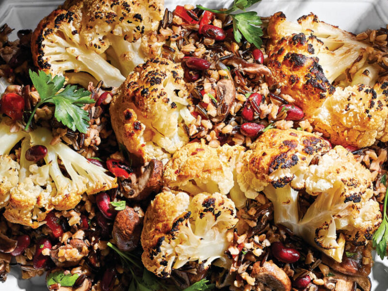 Whole Braised Cauliflower with Mixed-Grain Pilaf on a white serving platter