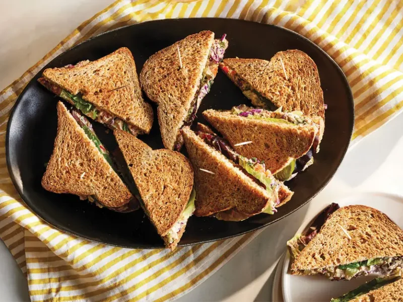 A plate of Hummus Salad Sandwiches cut in half diagonally