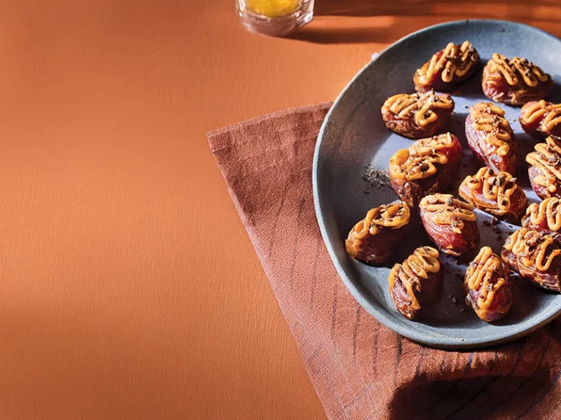 Kiki Nelson's Candy Bar Bites on a blue plate on a dark red kitchen towel with Scrabble tiles and a timer in the background