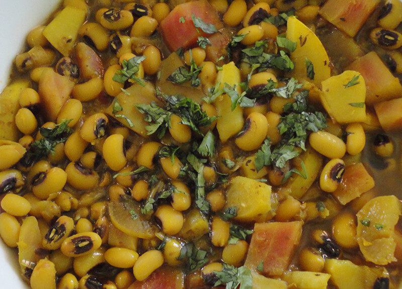 Top-down view of Black-Eyed Pea Stew in a white bowl on a wooden surface