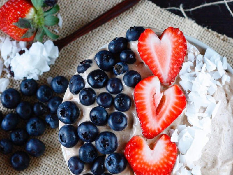 2-Ingredient Chocolate Banana Ice Cream garnished with sliced strawberries, blueberries, and coconut shreds