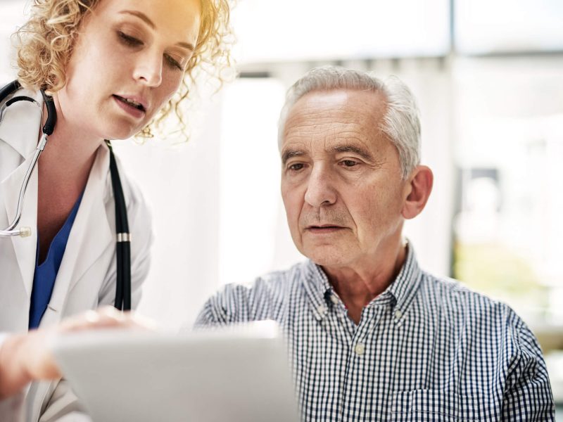Shot of a doctor showing a senior patient some information on a digital tablet in her office